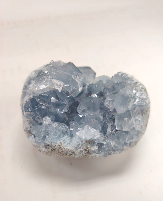 293克天青石晶洞正面，展示淡藍色晶體