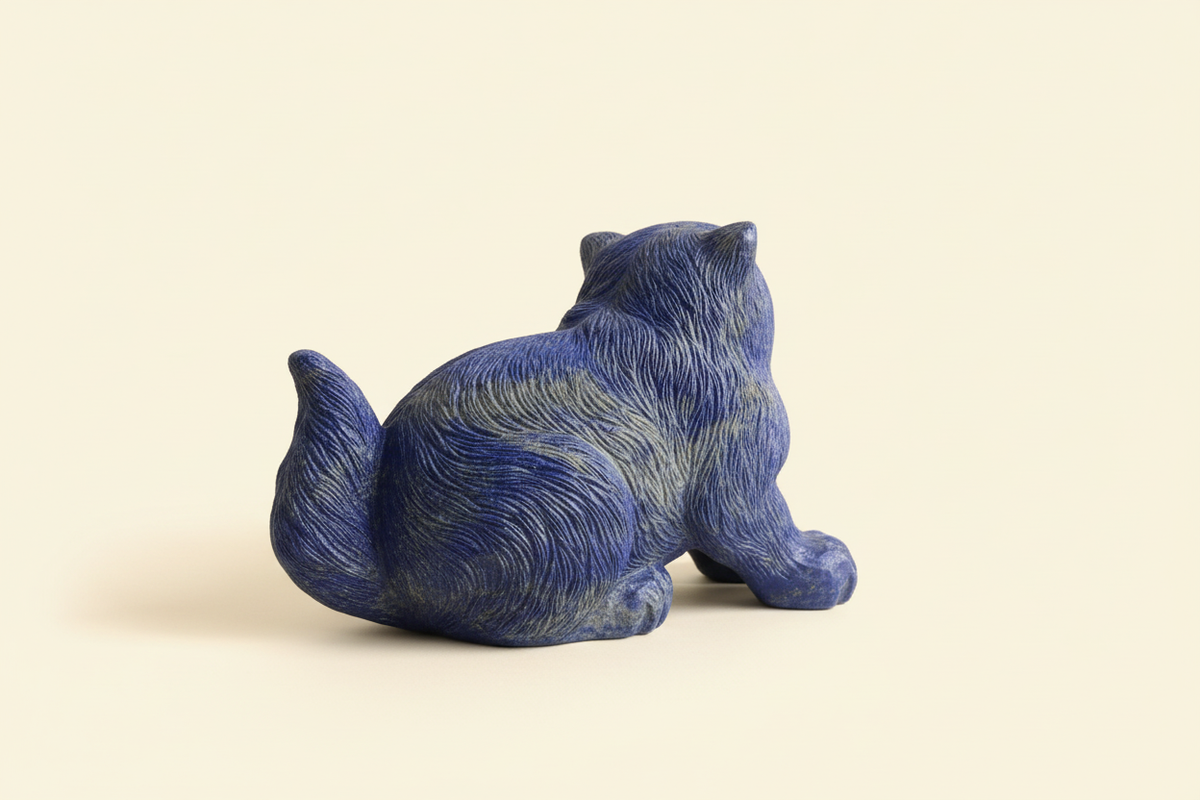 King Lapis blue lapis lazuli cat sculpture side view on a warm ivory background